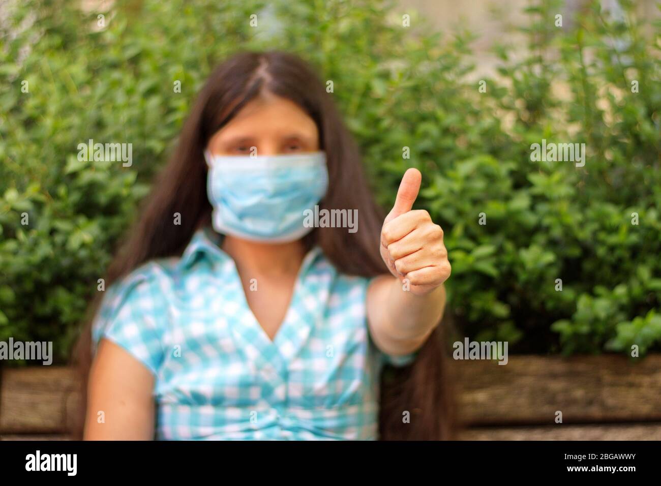 Portrait of young woman gesturing with hand wearing medicine mask Stock Photo