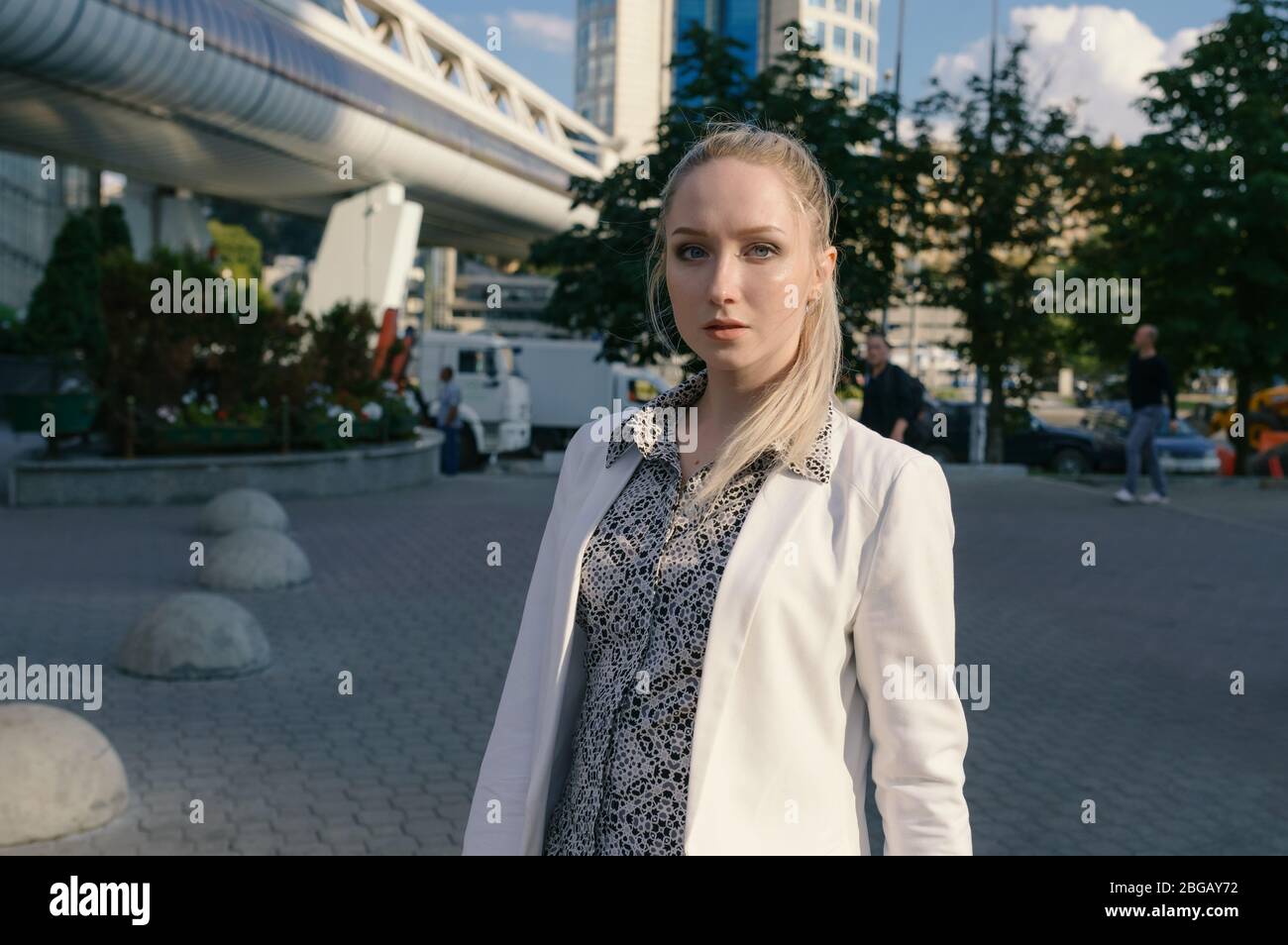 City portrait of beautiful young woman in a white blouse. Selective ...