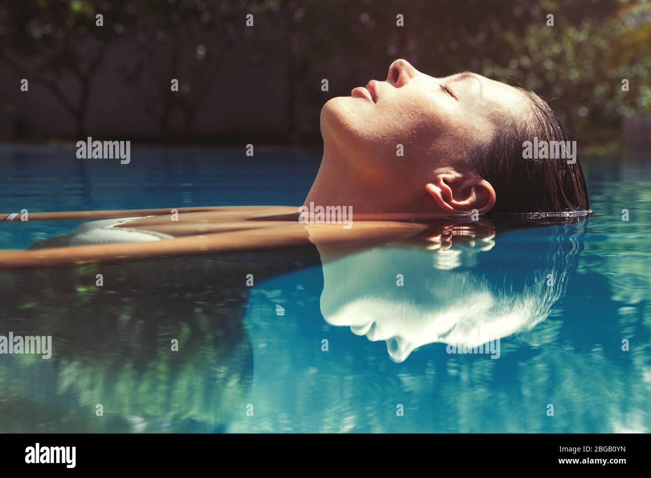 Woman relaxing in the pool water. A beautiful woman floating in water