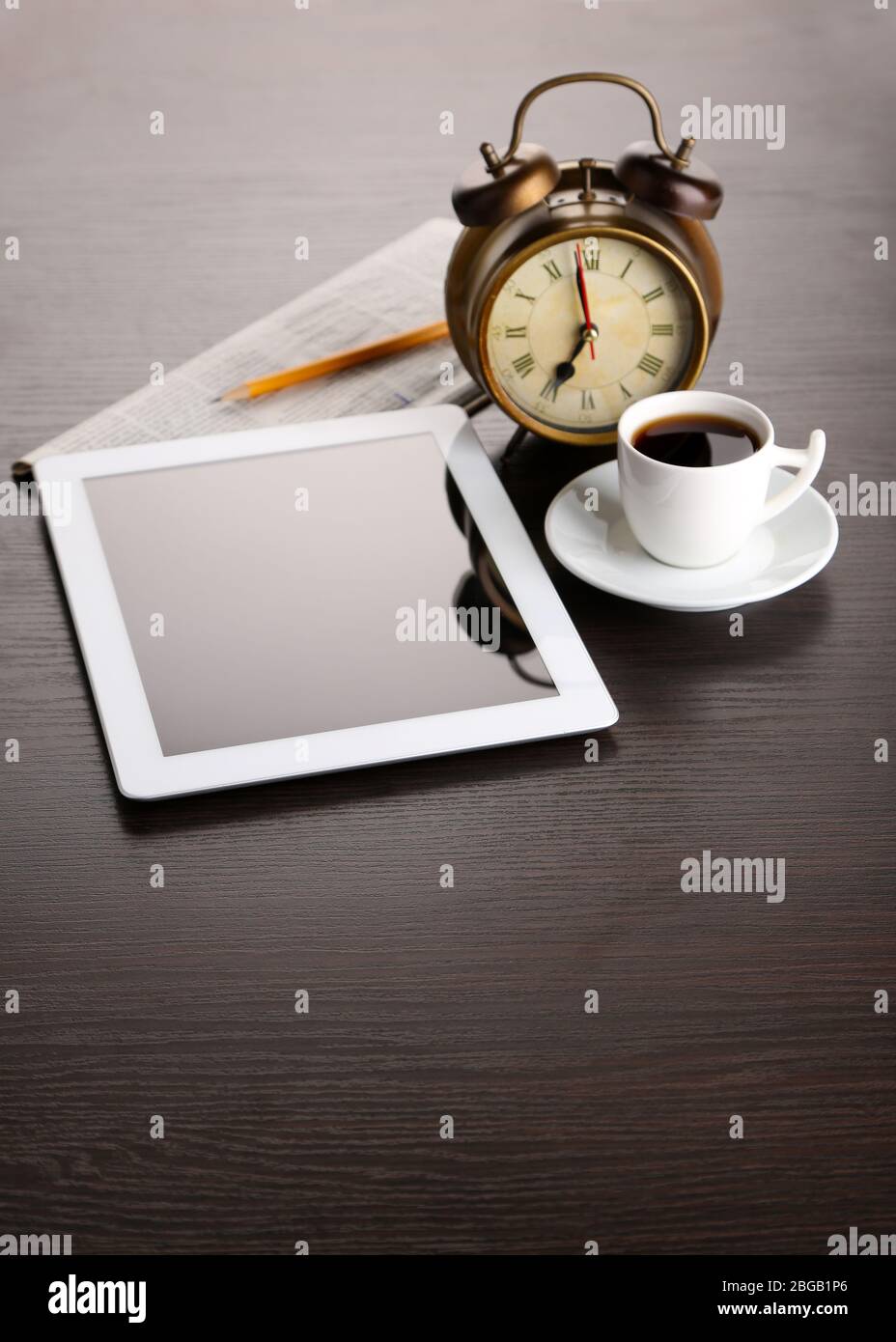 https://c8.alamy.com/comp/2BGB1P6/tablet-newspaper-cup-of-coffee-and-alarm-clock-on-wooden-table-2BGB1P6.jpg