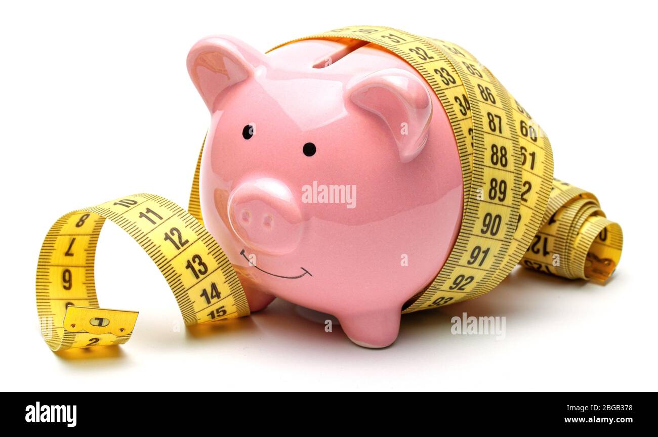 Pink piggy bank and yellow measuring tape isolated on a white ...