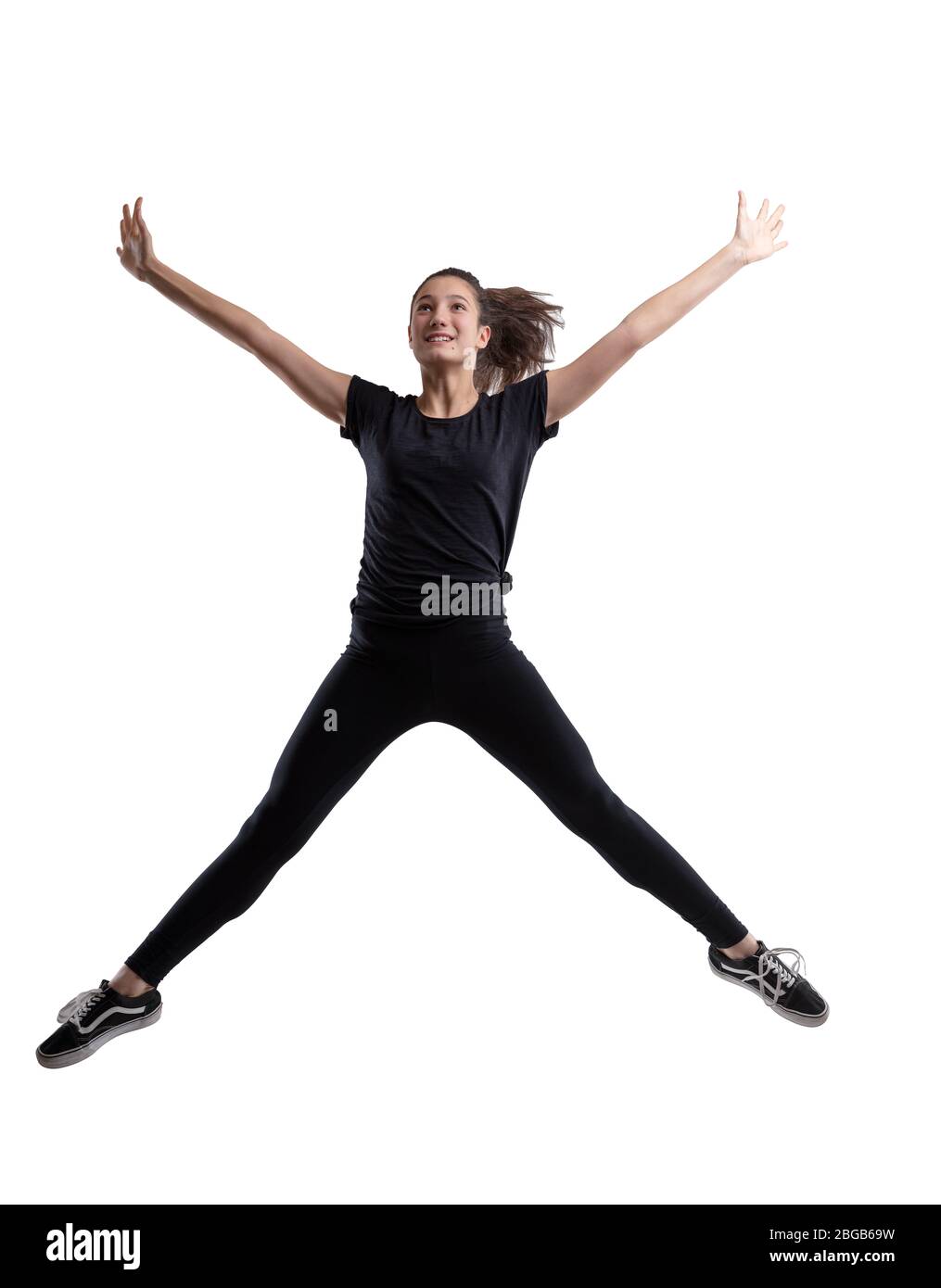 Athlete slender young woman leaping in the air with her arms and legs outstretched and a happy vivacious smile isolated on white in full length Stock Photo