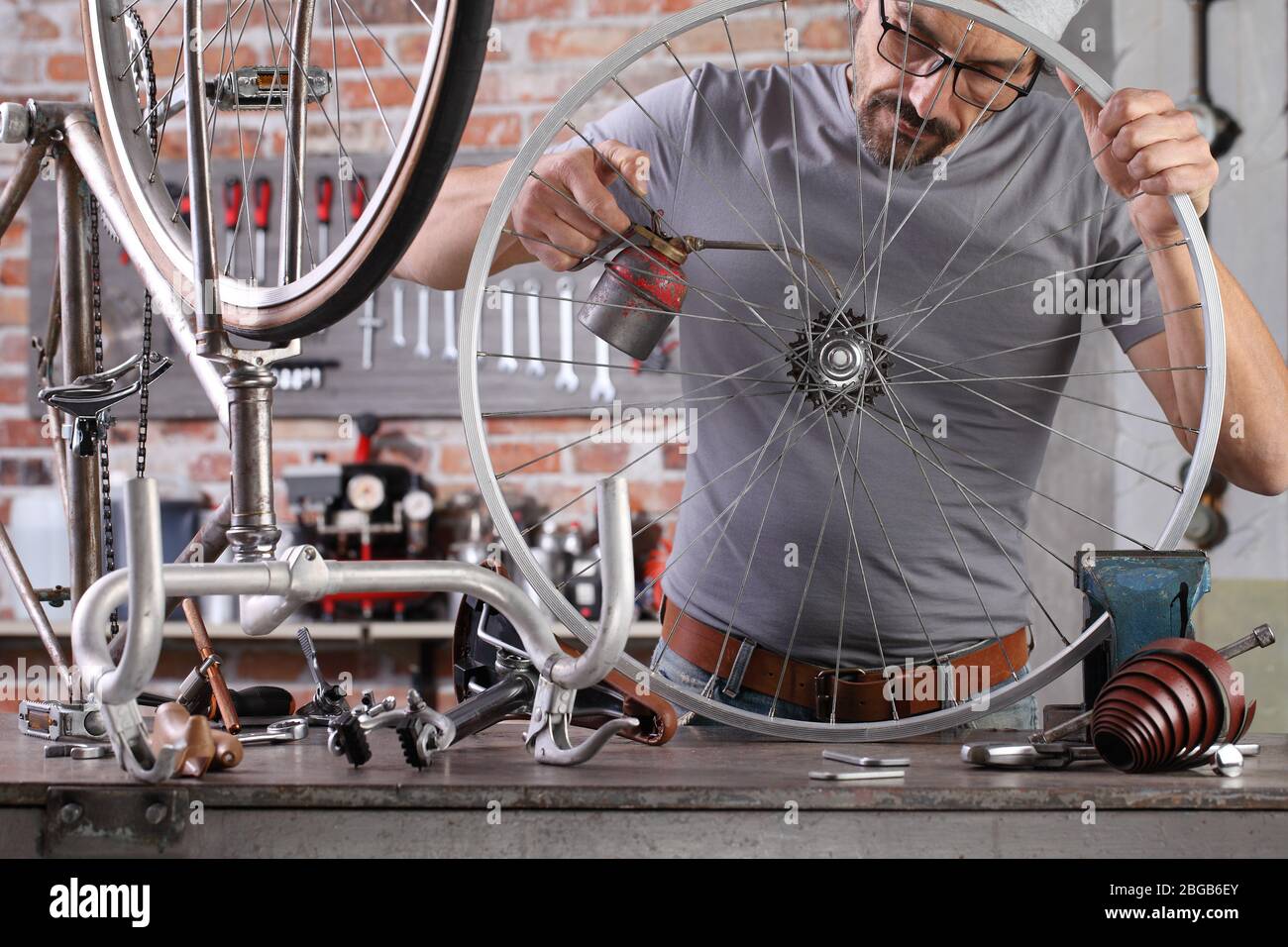 man repair the vintage bicycle oil gears in garage on the