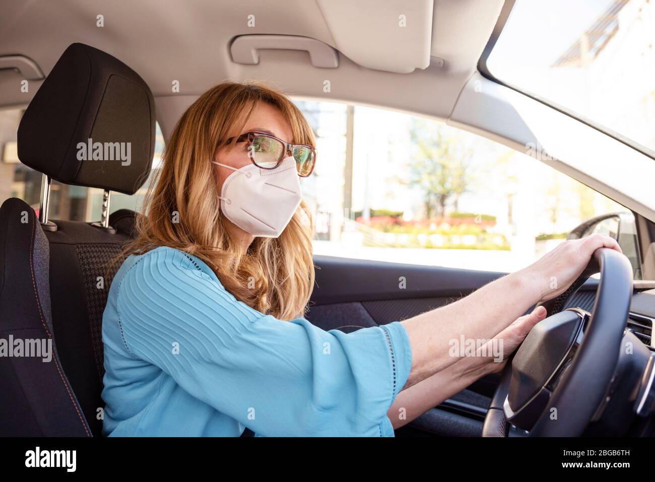 Shot of middle aged woman wearing face mask while driving her car during  coronavirus pandemic Stock Photo - Alamy