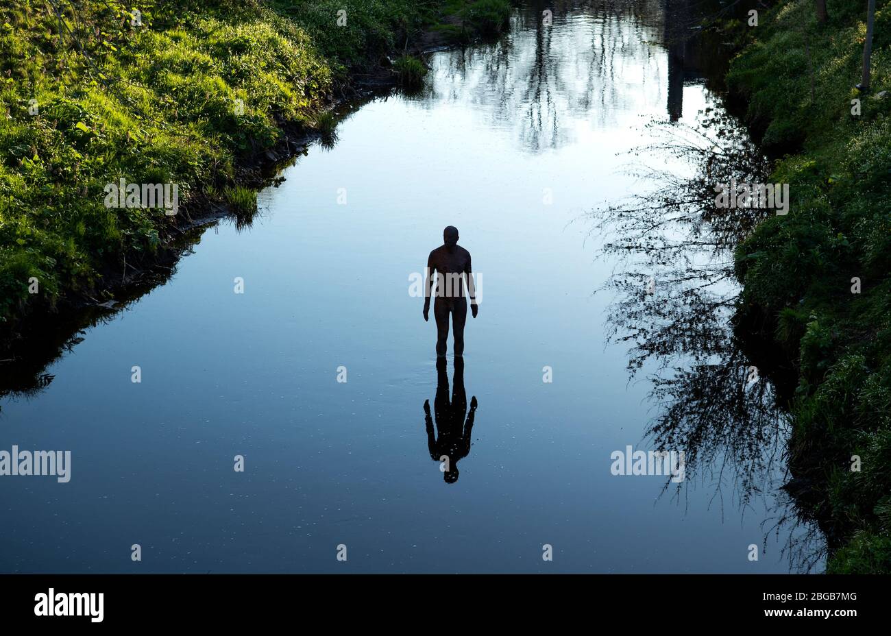One of artist Antony Gormley's "6 TIMES" statues in the Water of Leith