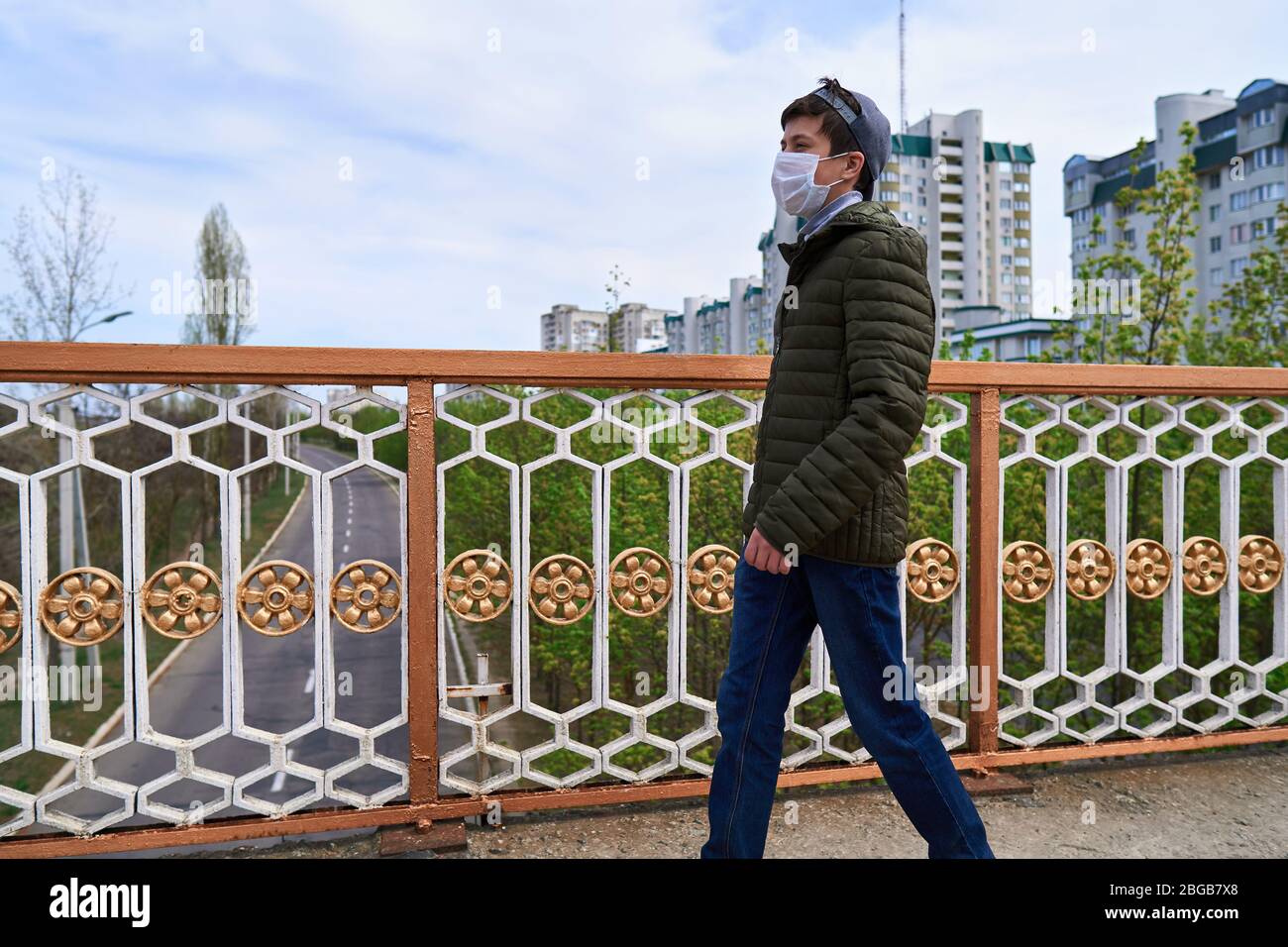 Image showcasing teen boy walks down the street during the day, a pedestrian walkway and ...