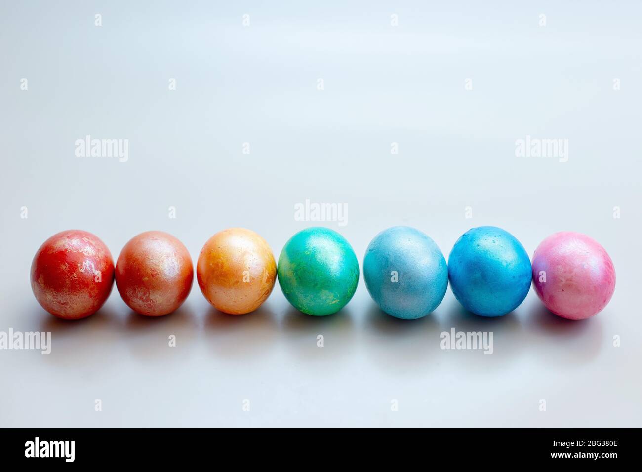 Rainbow colored eggs: red, orange, yellow,green, light blue, blue and purple, lay next to a ...