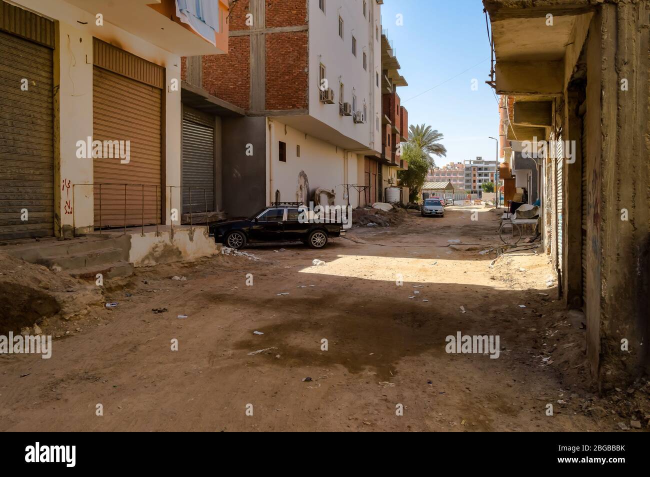 Egypt, Hurghada, dirt street with multi-family houses and old cars Stock Photo