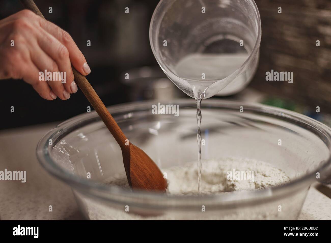 Mixing together ingredients of hot-water crust pastry dough, using wooden  spoon Stock Photo - Alamy