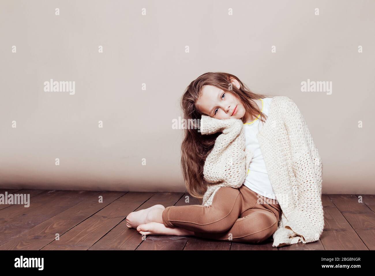 little girl sitting on the floor and sad Stock Photo - Alamy