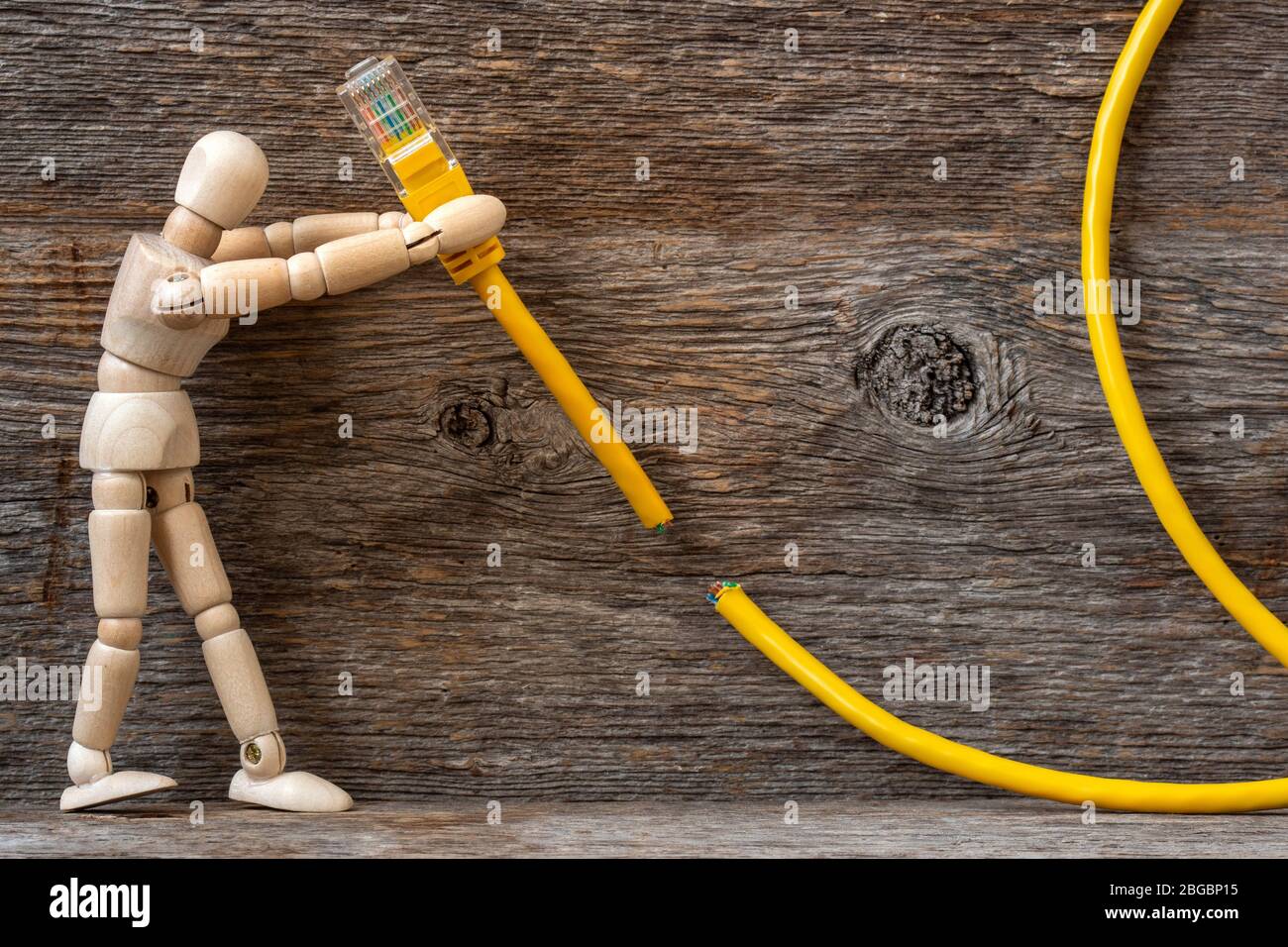 Wooden doll and internet cable on wooden background. Internet cencorship or internet connection repair. Stock Photo