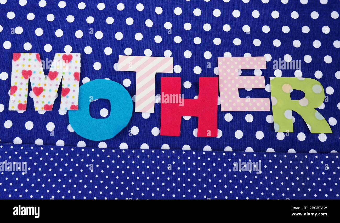 Mother lettering of handmade paper letters on blue polka background