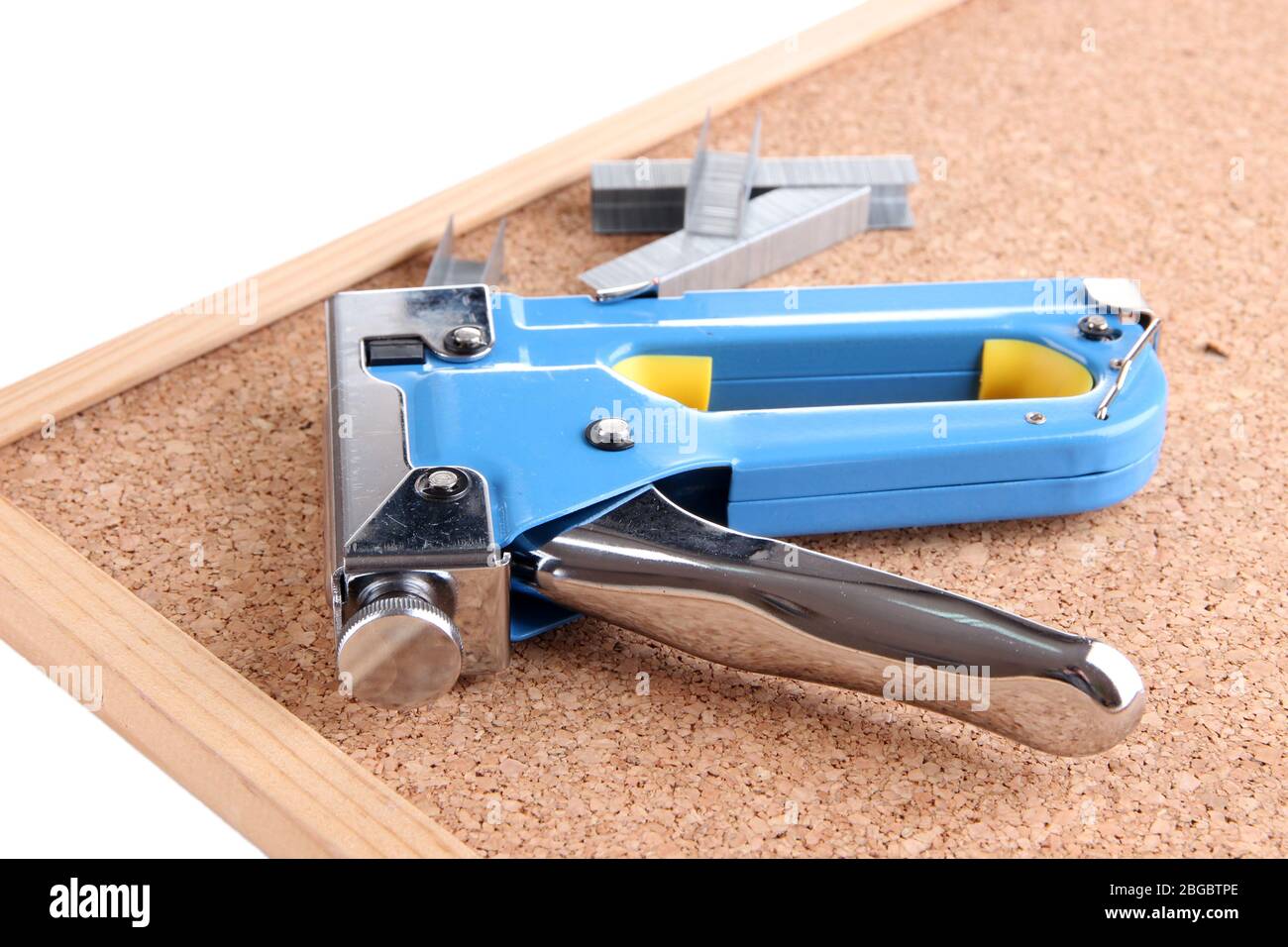 Construction stapler and staples on cork board close up Stock Photo