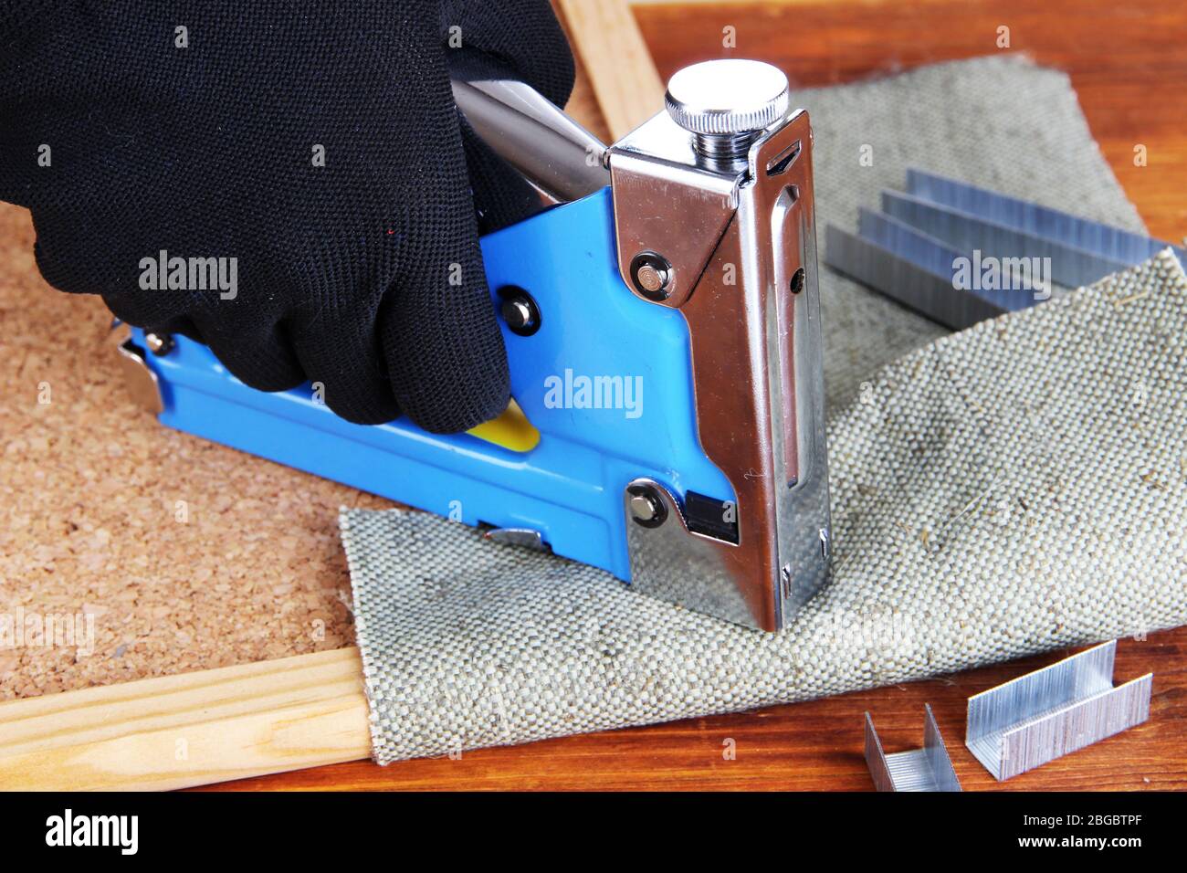 Fastening fabric and board using construction stapler Stock Photo Alamy