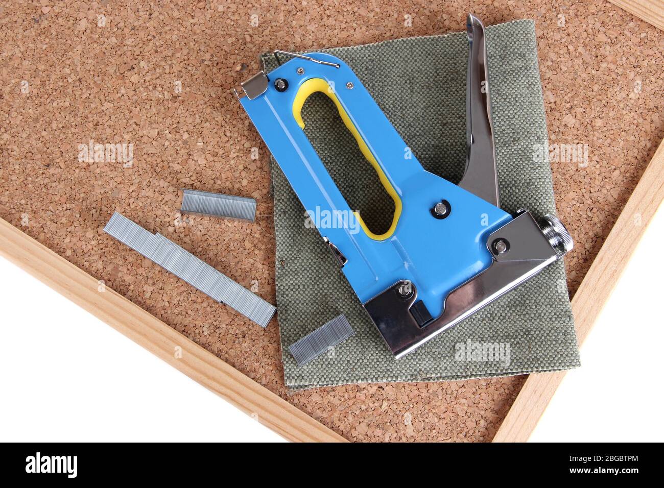Construction stapler and staples on cork board close up Stock Photo
