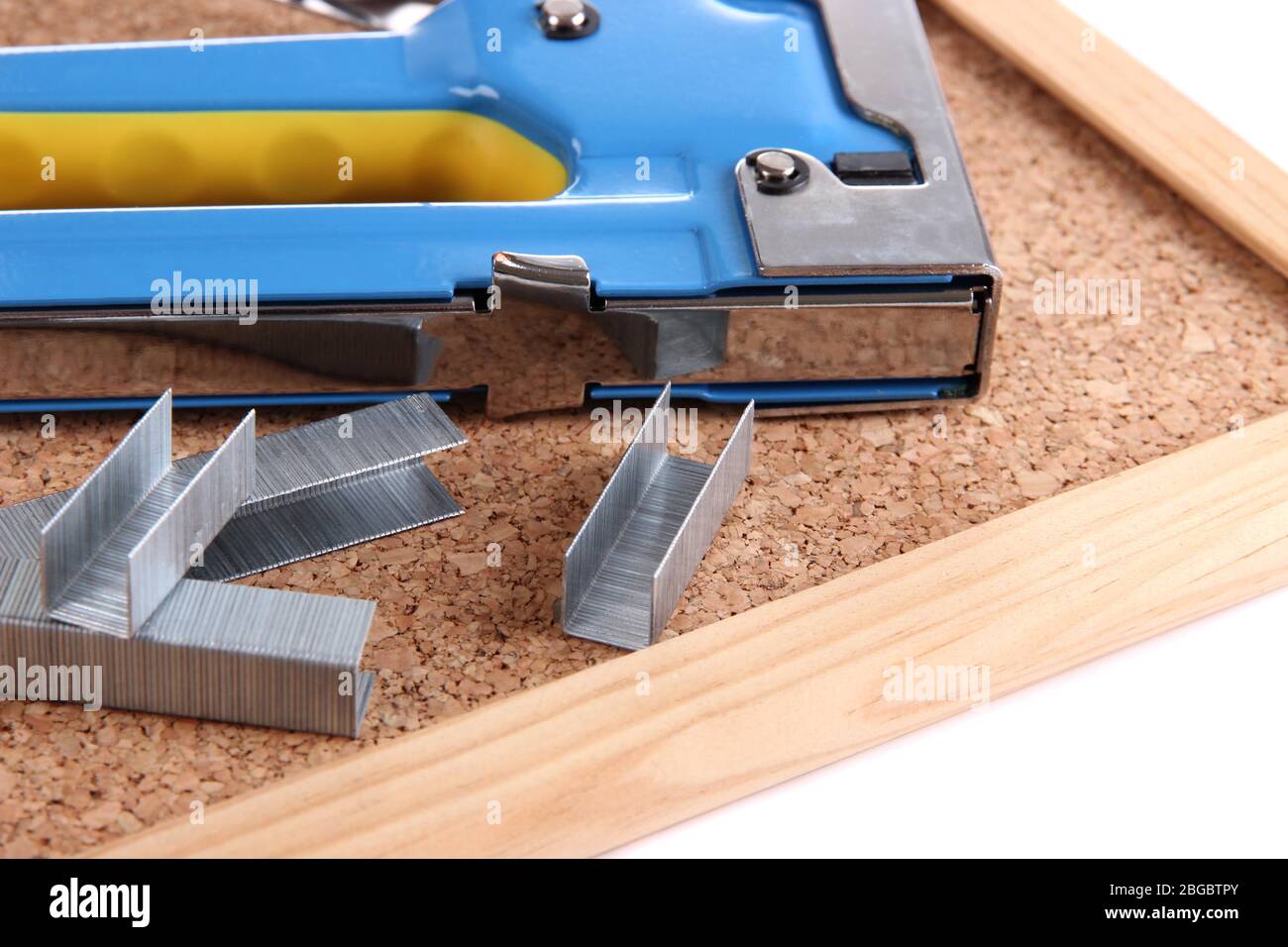 Construction stapler and staples on cork board close up Stock Photo Alamy