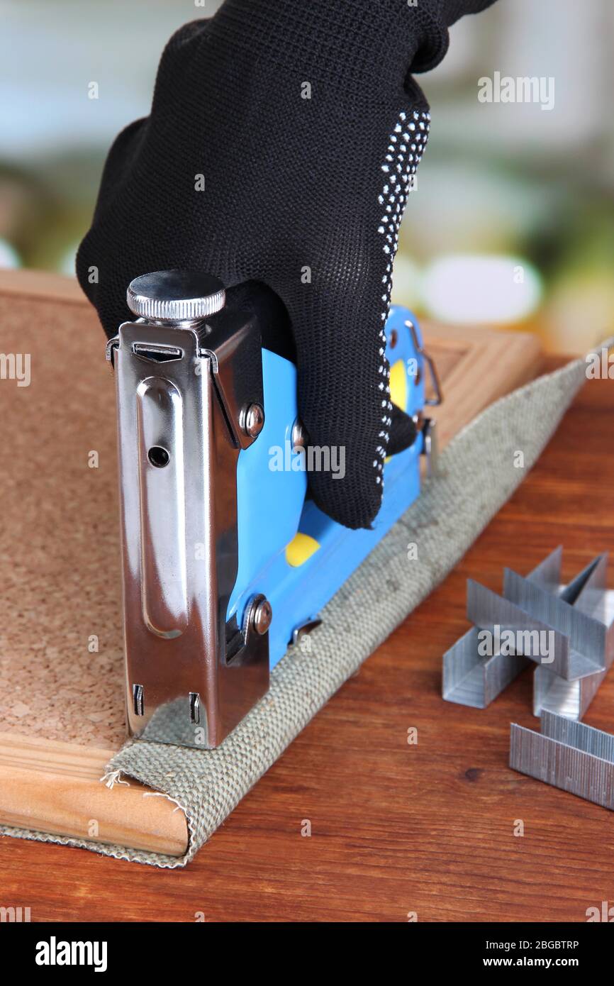 Fastening fabric and board using construction stapler on bright