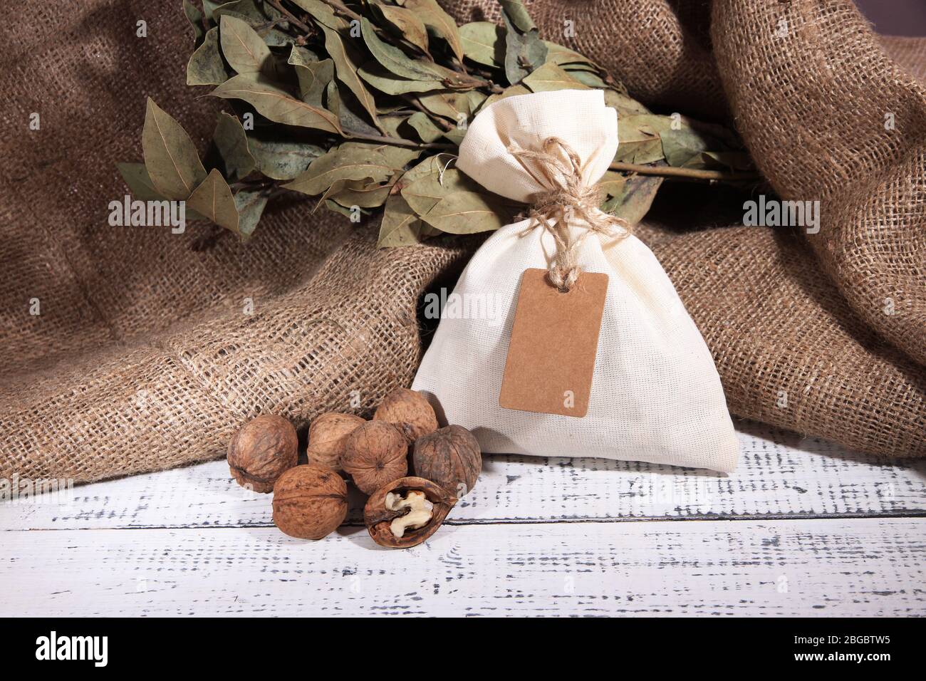 Sack full with spices, on wooden table, on sackcloth background Stock Photo
