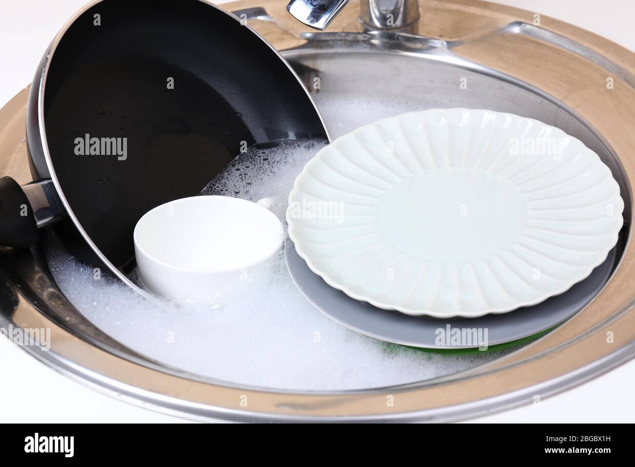 Utensils soaking in kitchen sink Stock Photo Alamy