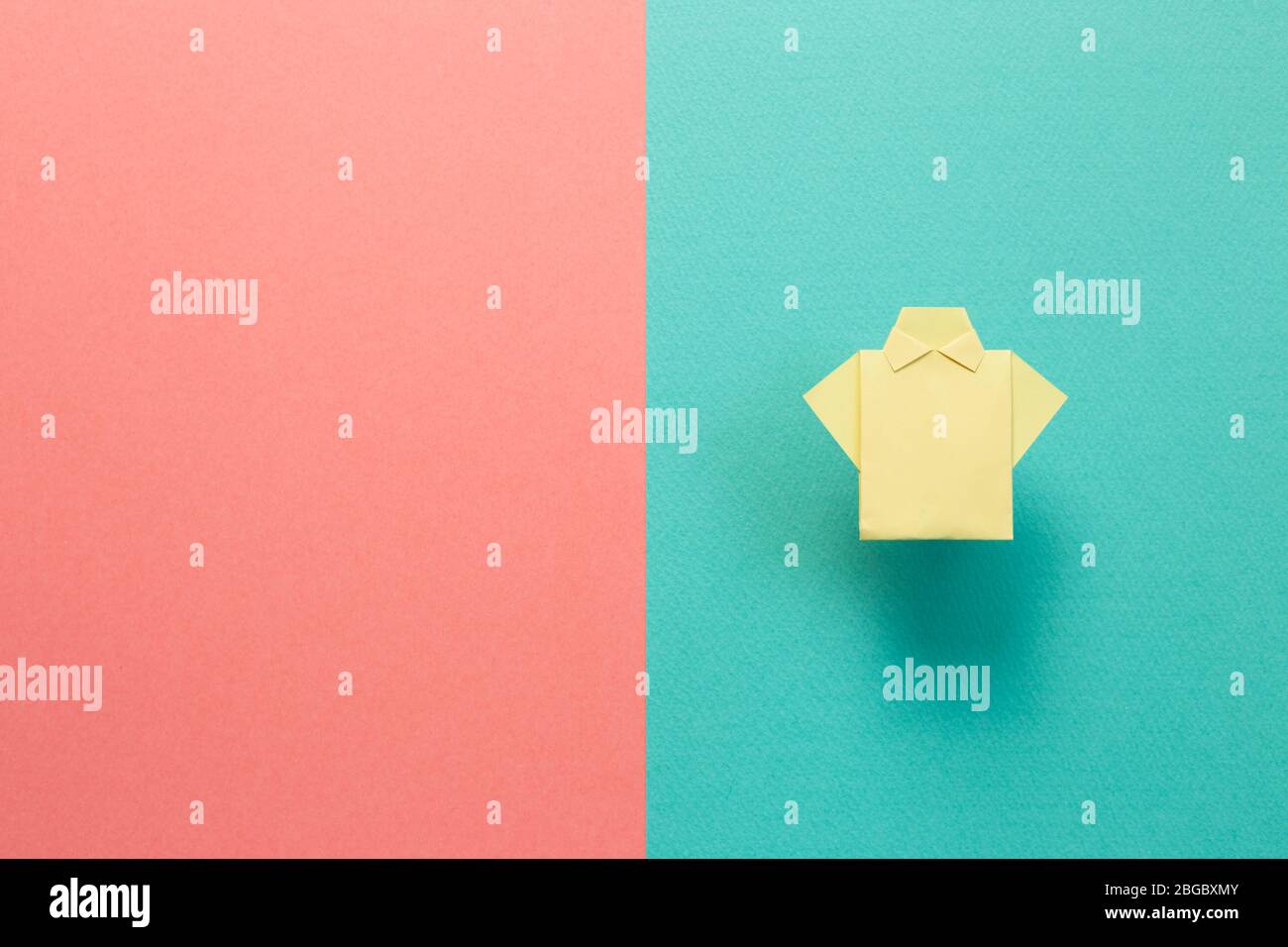 Yellow paper shirt origami on green pink background Stock Photo