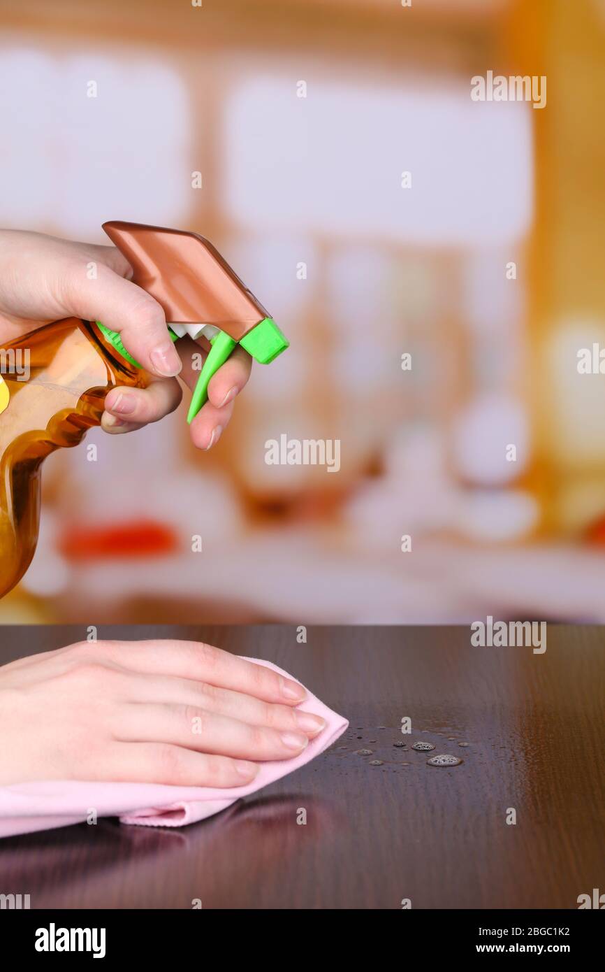 Hand cleaning wooden table with furniture polish Stock Photo Alamy