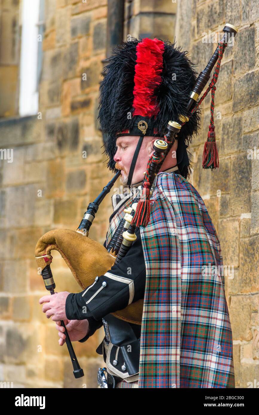 Edinburgh, Scotland Dec 2018. Scottish bagpiper dressed in traditional red and black tartan
