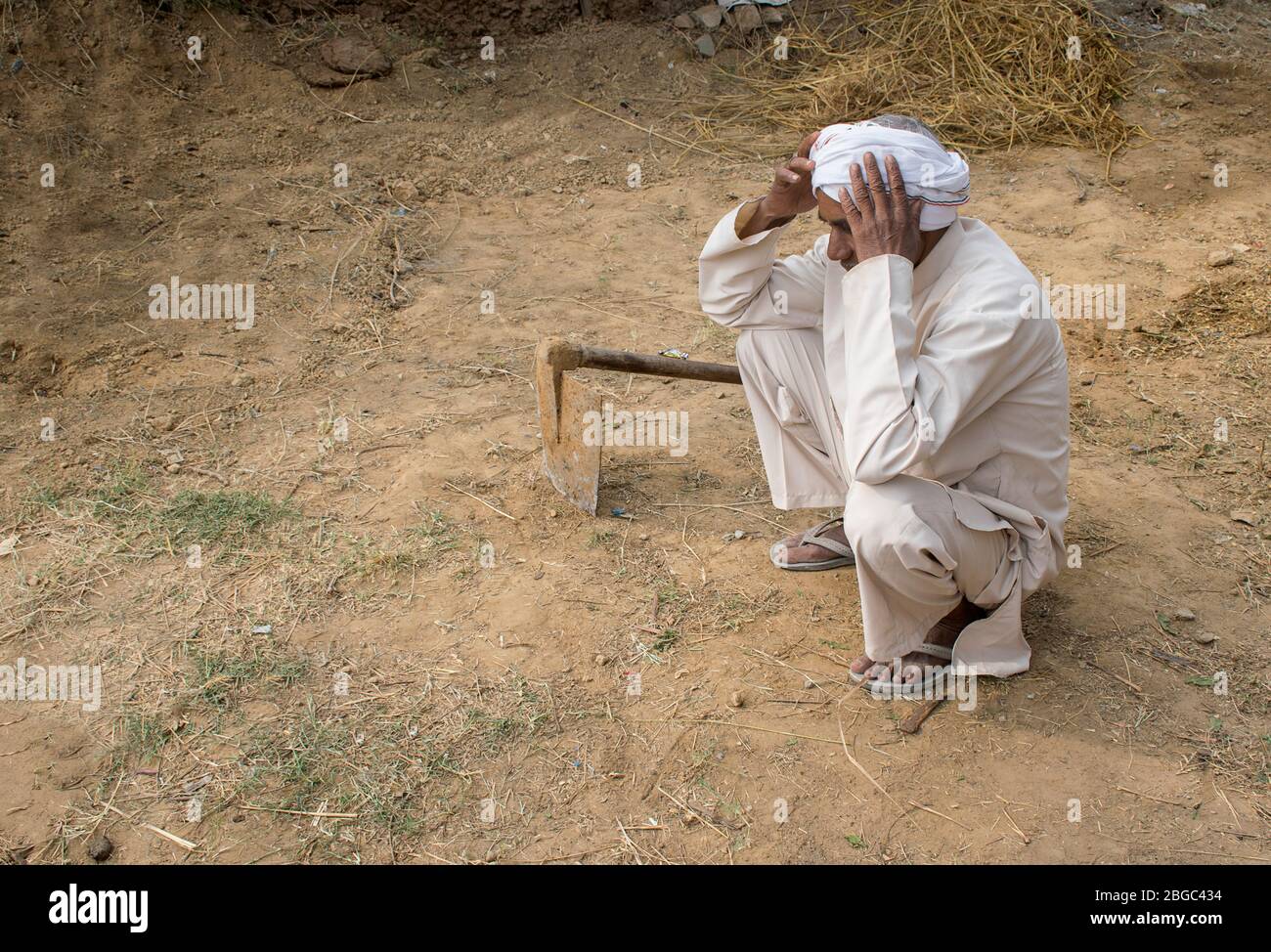 sad farmer holding his head and lost in thought Stock Photo - Alamy