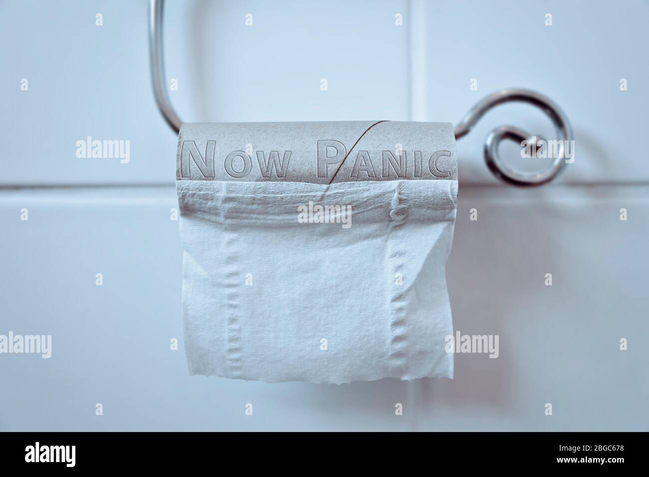 Empty Toilet Loo Roll reads 'NOW PANIC' Panic Buying Toilet Paper concept Coronavirus Covid-19 Pandemic Stock Photo