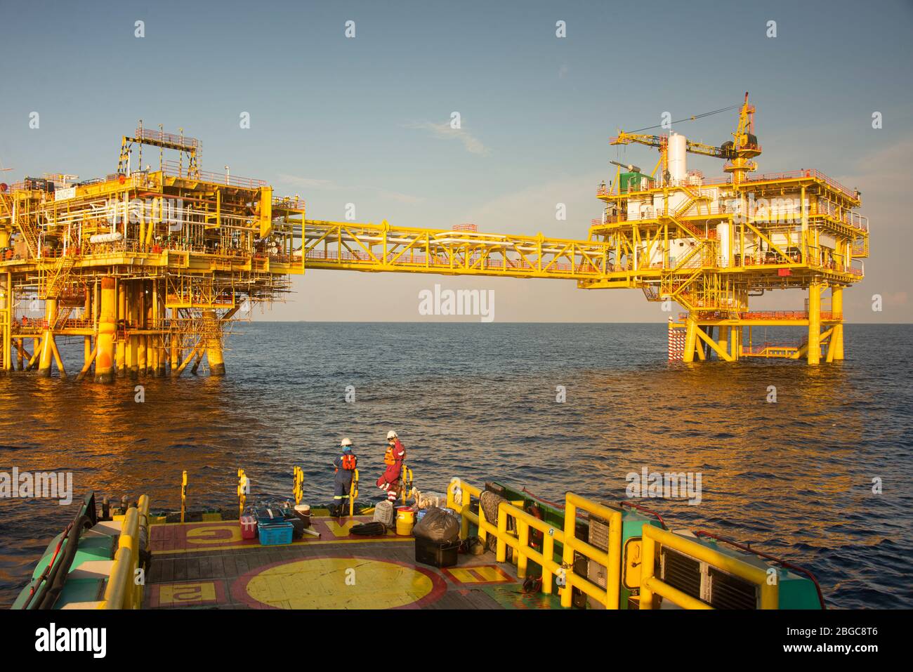 accommodation work boat attach to oil platform at sea form scheduled maintenance Stock Photo