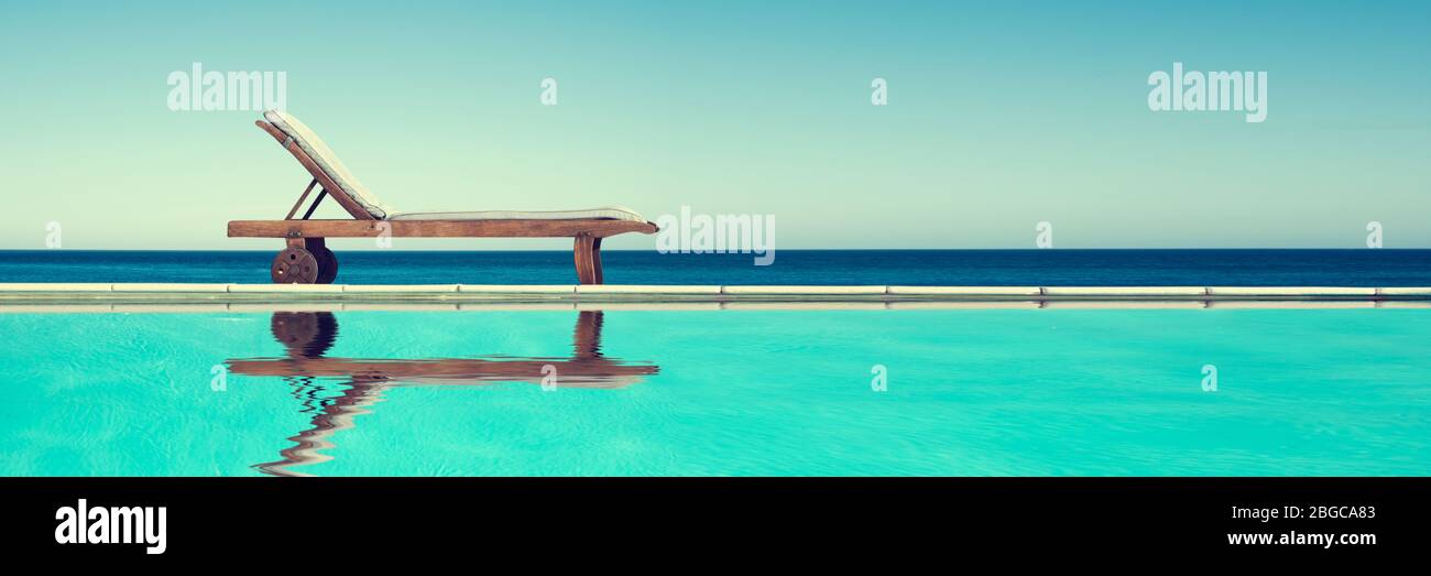 Reclining chair near a swimming pool, travel panoramic background with copy-space Stock Photo