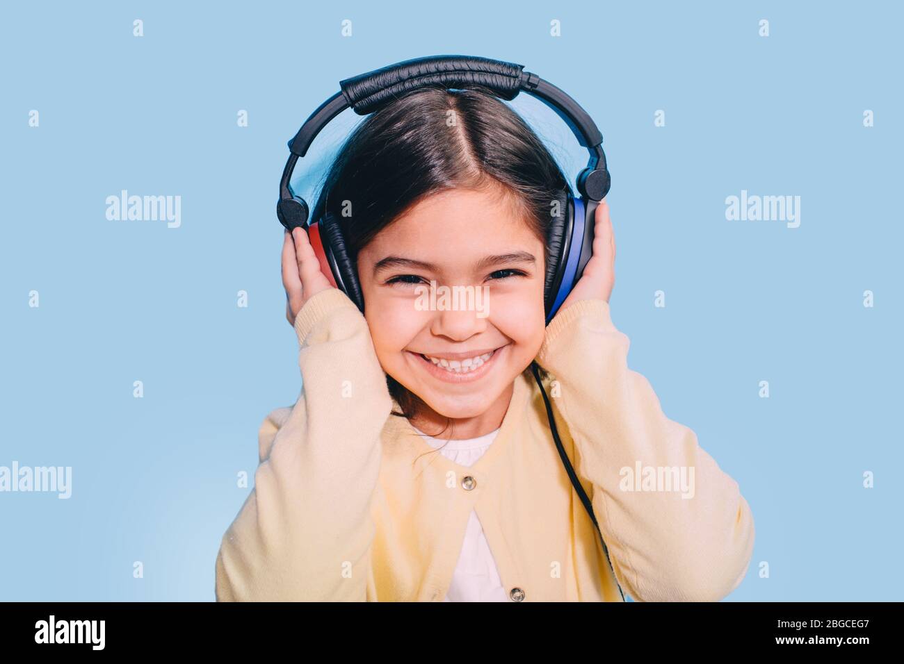 Cute little mixed race child while procedure hearing exam. Girl wearing special headphones getting hearing test, audiometry Stock Photo