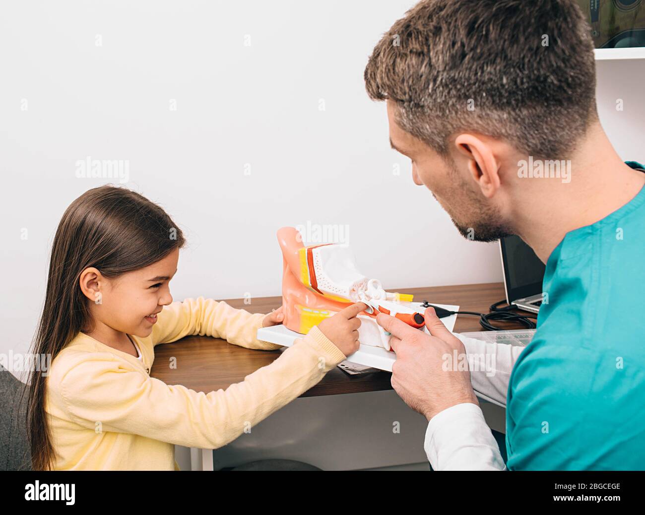 Little child with pediatrician, he explains how the ear works Stock Photo