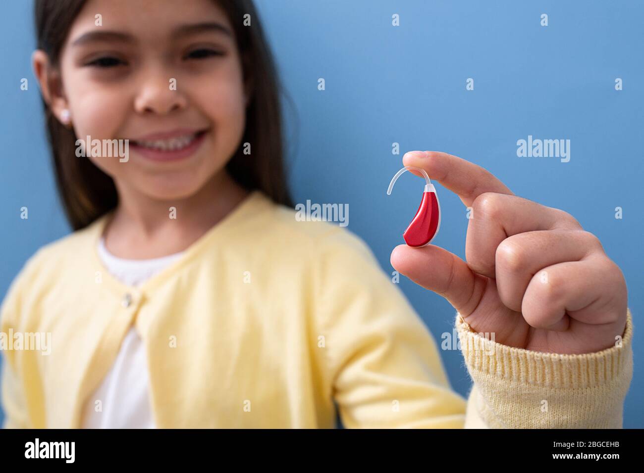 advertising hearing aid for children, a mixed race child shows a