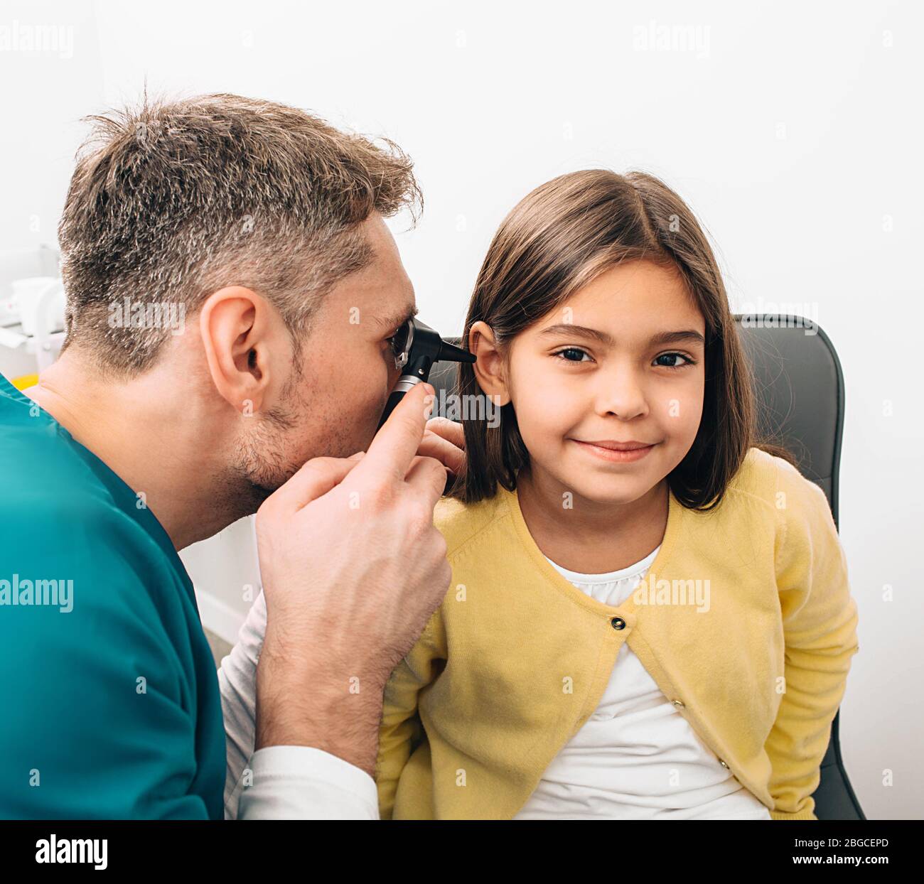 Ear exam. Pediatrician examining little mixed race child with otoscope, hearing exam of child