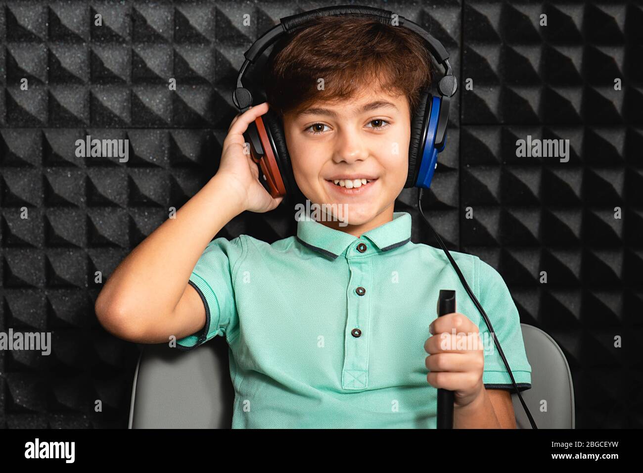 Positive little mixed race boy wearing headphones having hearing exam