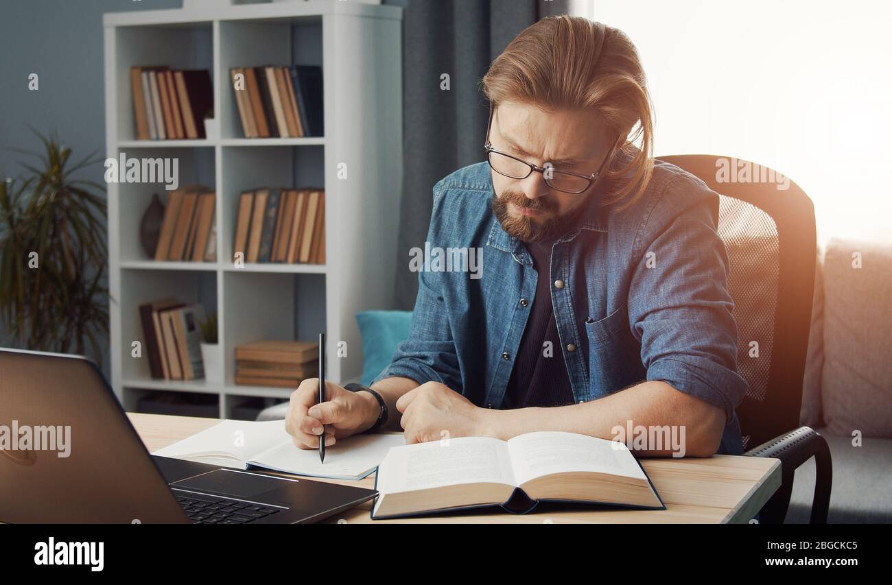 Man looking book making notes Stock Photo