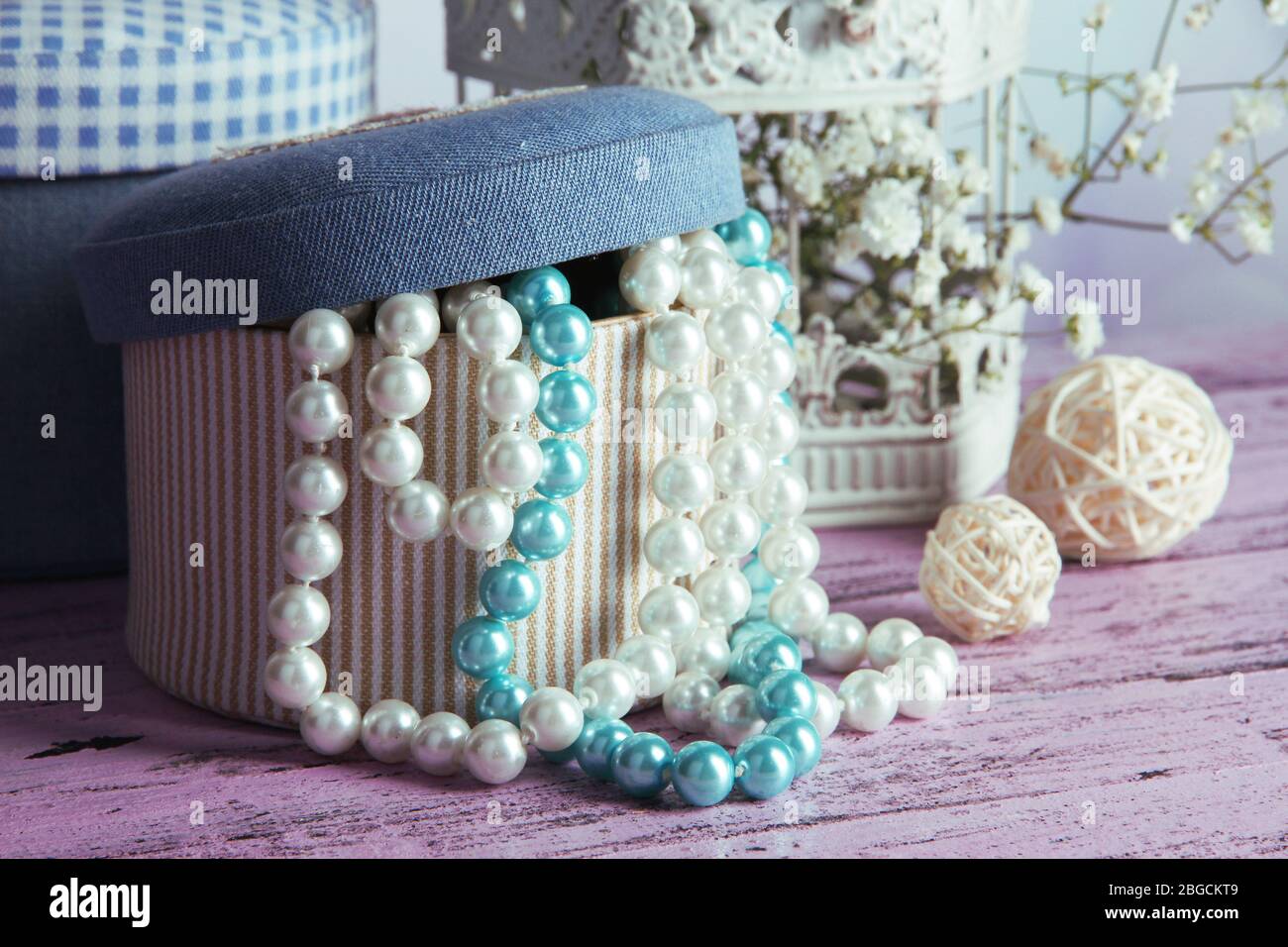 Decorative boxes with beads and flowers on table close up Stock Photo