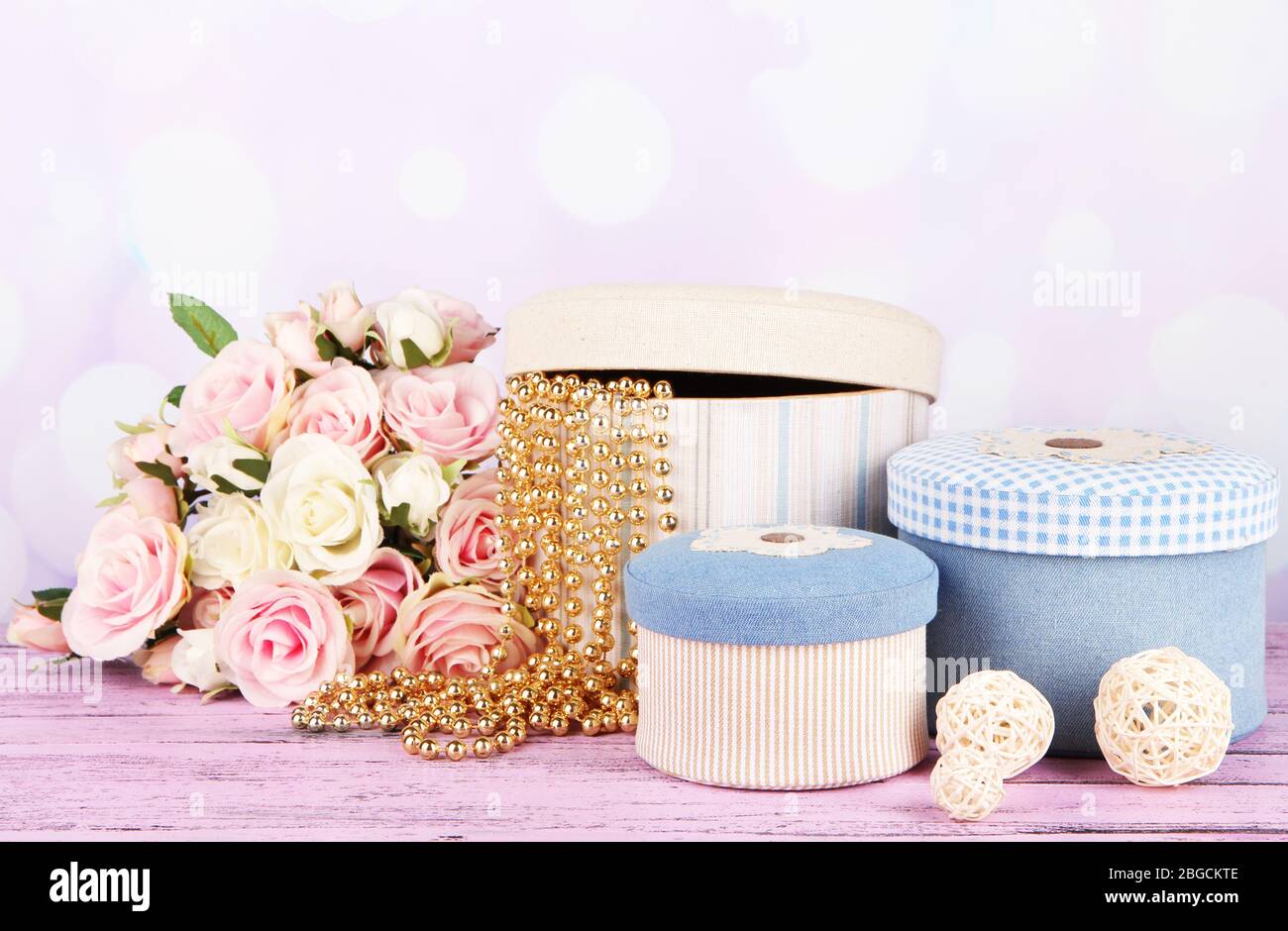 Decorative boxes with flowers on table on bright background Stock Photo