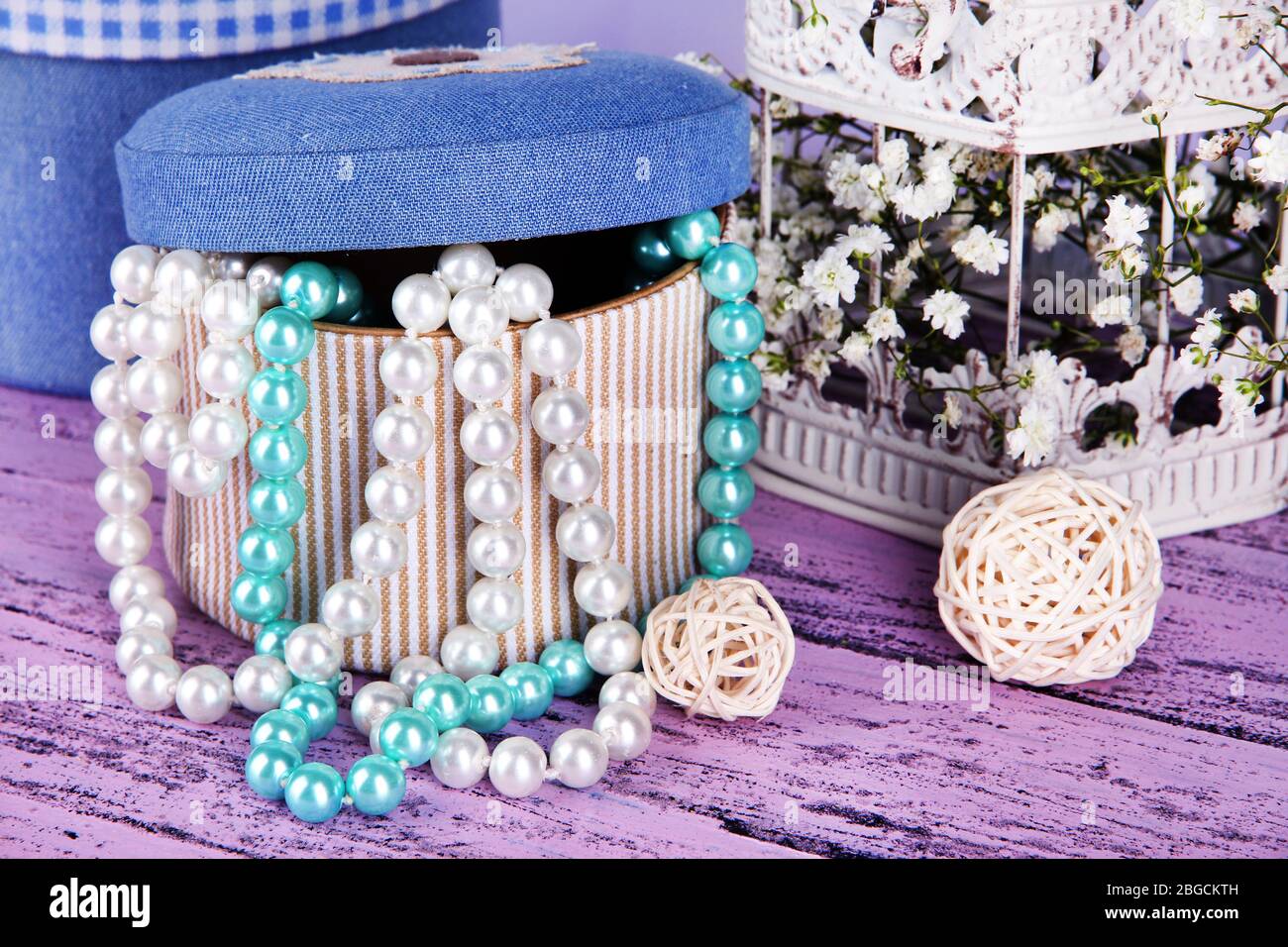Decorative boxes with beads and flowers on table close up Stock Photo