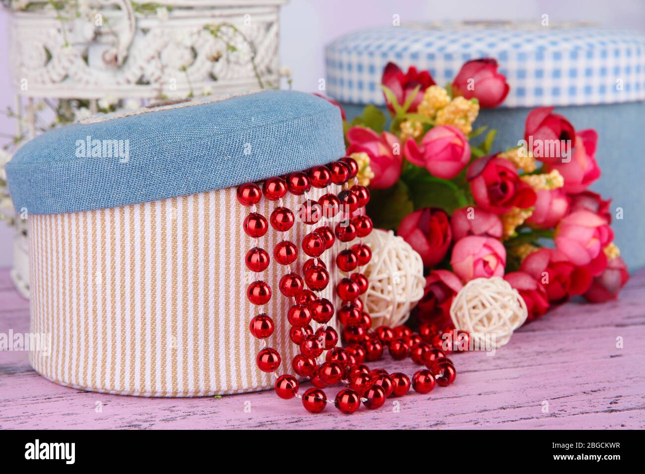Decorative boxes with beads and flowers on table close up Stock Photo