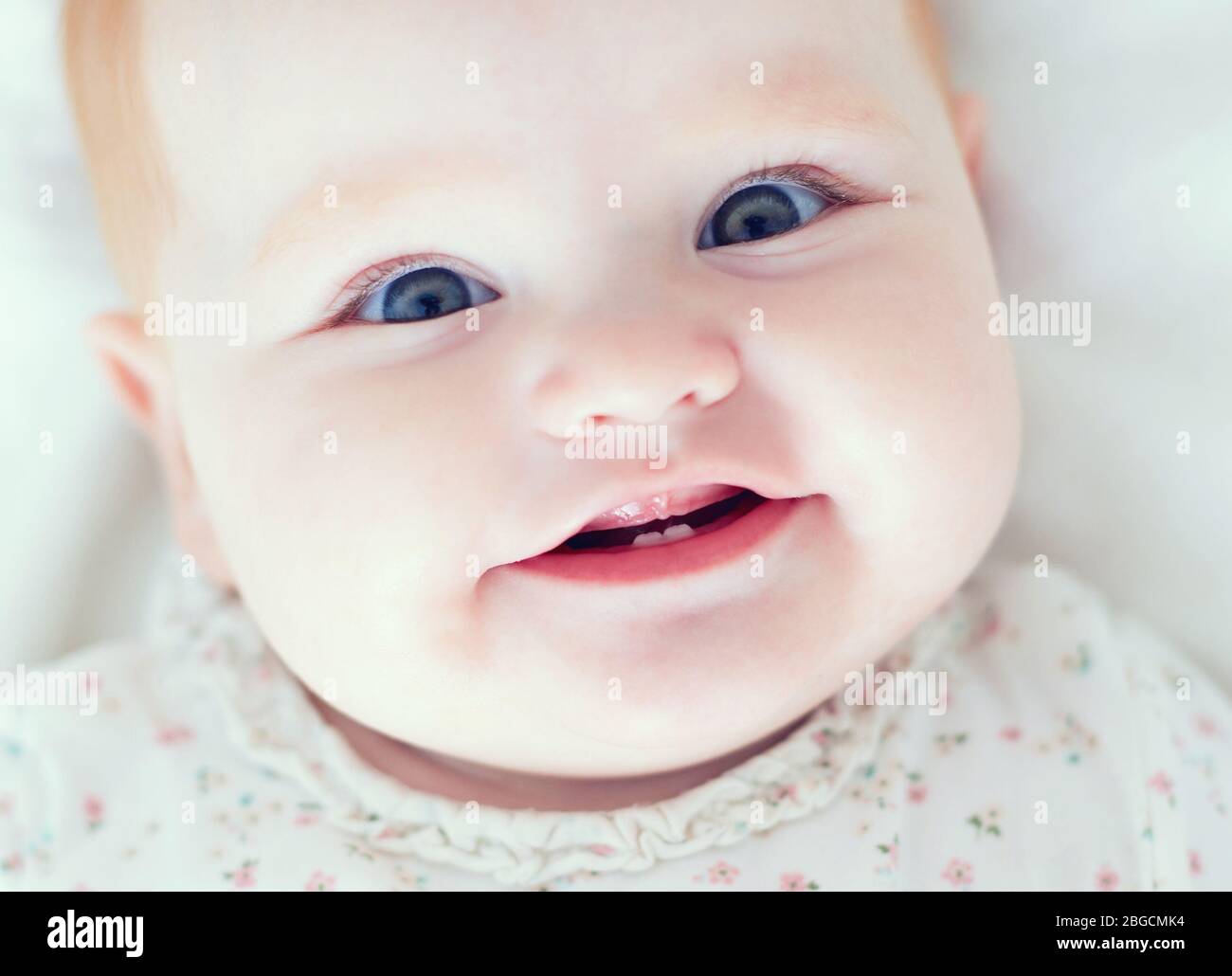 top view of infant baby girl, smilyng with her first two teeth Stock Photo