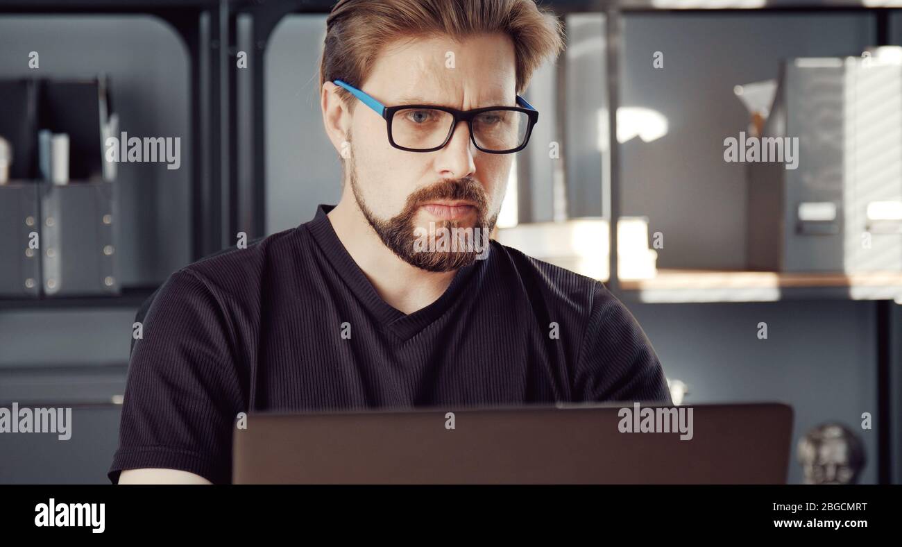 Serious man using laptop Stock Photo
