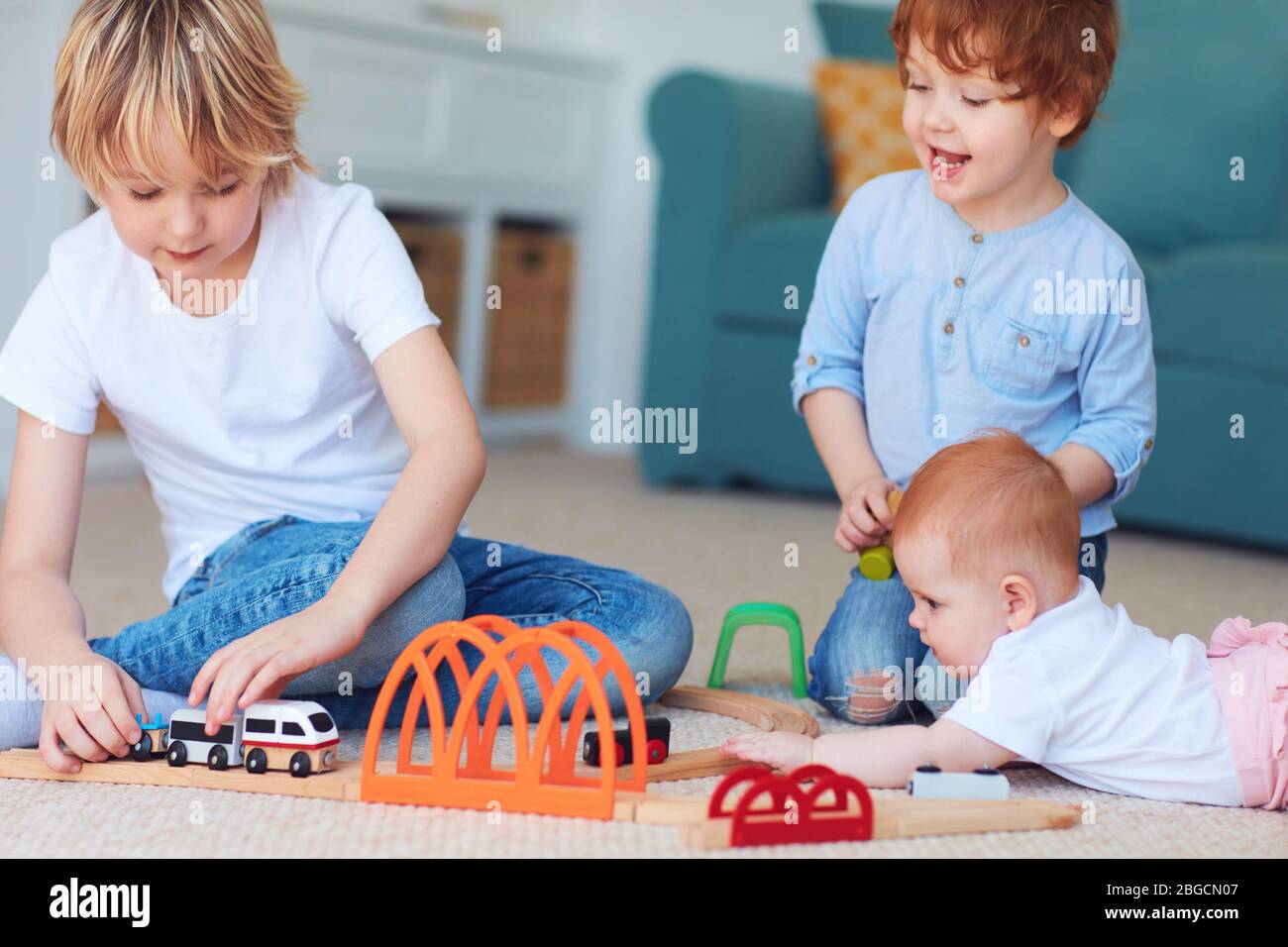 cute kids, siblings playing toys together on the carpet at home Stock