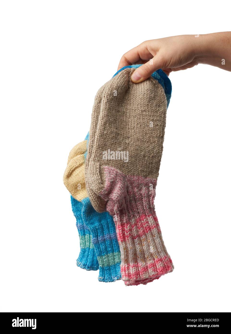 female hand holds a pair of knitted woolen socks, warm clothes, item is isolated on a white background Stock Photo