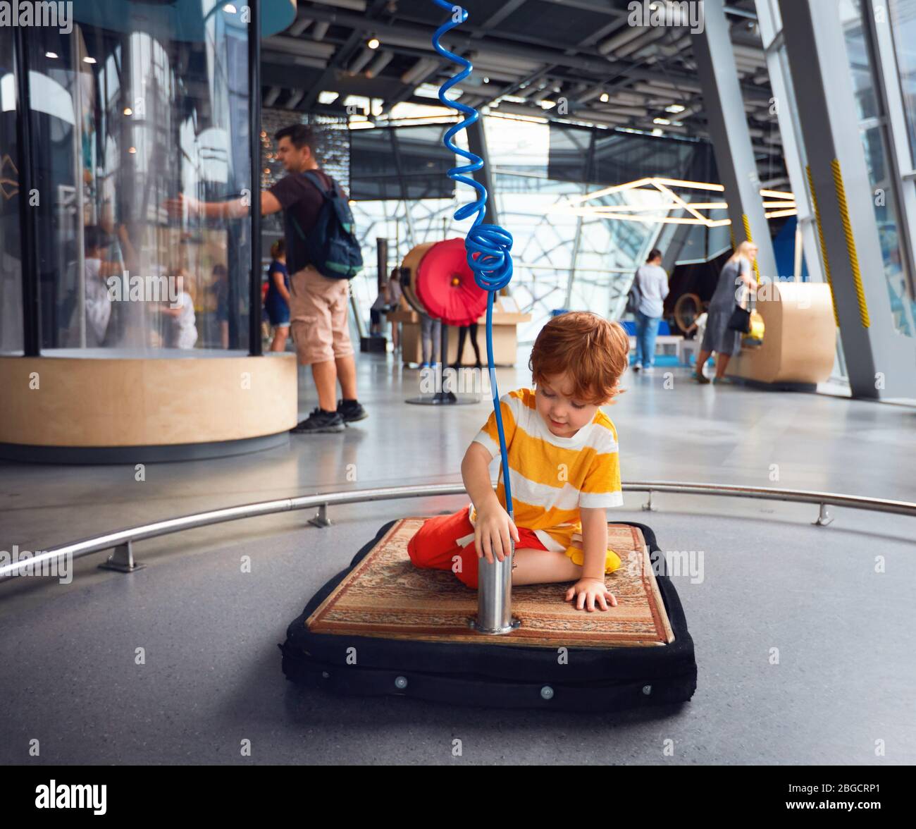 WARSAW, POLAND - June 20, 2019: Curious kid exploring the floating features of rug in combination with the air pump at the Copernicus Science Centre i Stock Photo