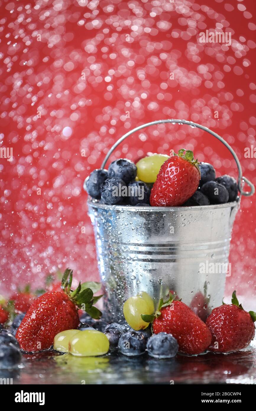 Fruit salad close up in metal bucket. Strawberry, grape, blueberry ...