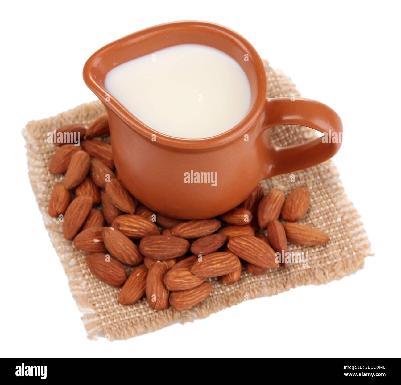 Almond milk in jug with almonds, isolated on white Stock Photo