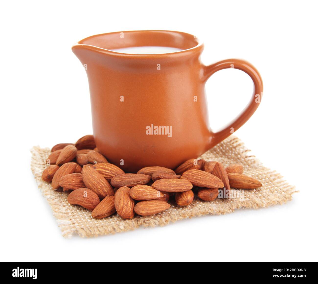 Almond milk in jug with almonds, isolated on white Stock Photo