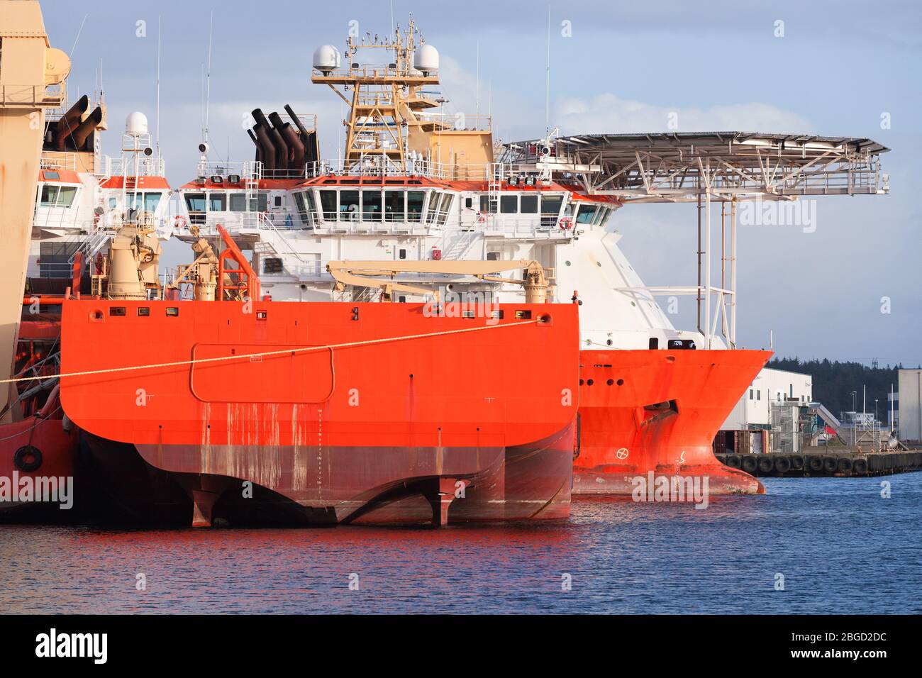 Fleet of offshore vessels moored in Norwegian port at sunny day Stock Photo