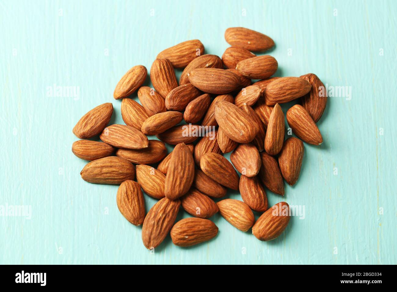 Almonds on color wooden background Stock Photo - Alamy